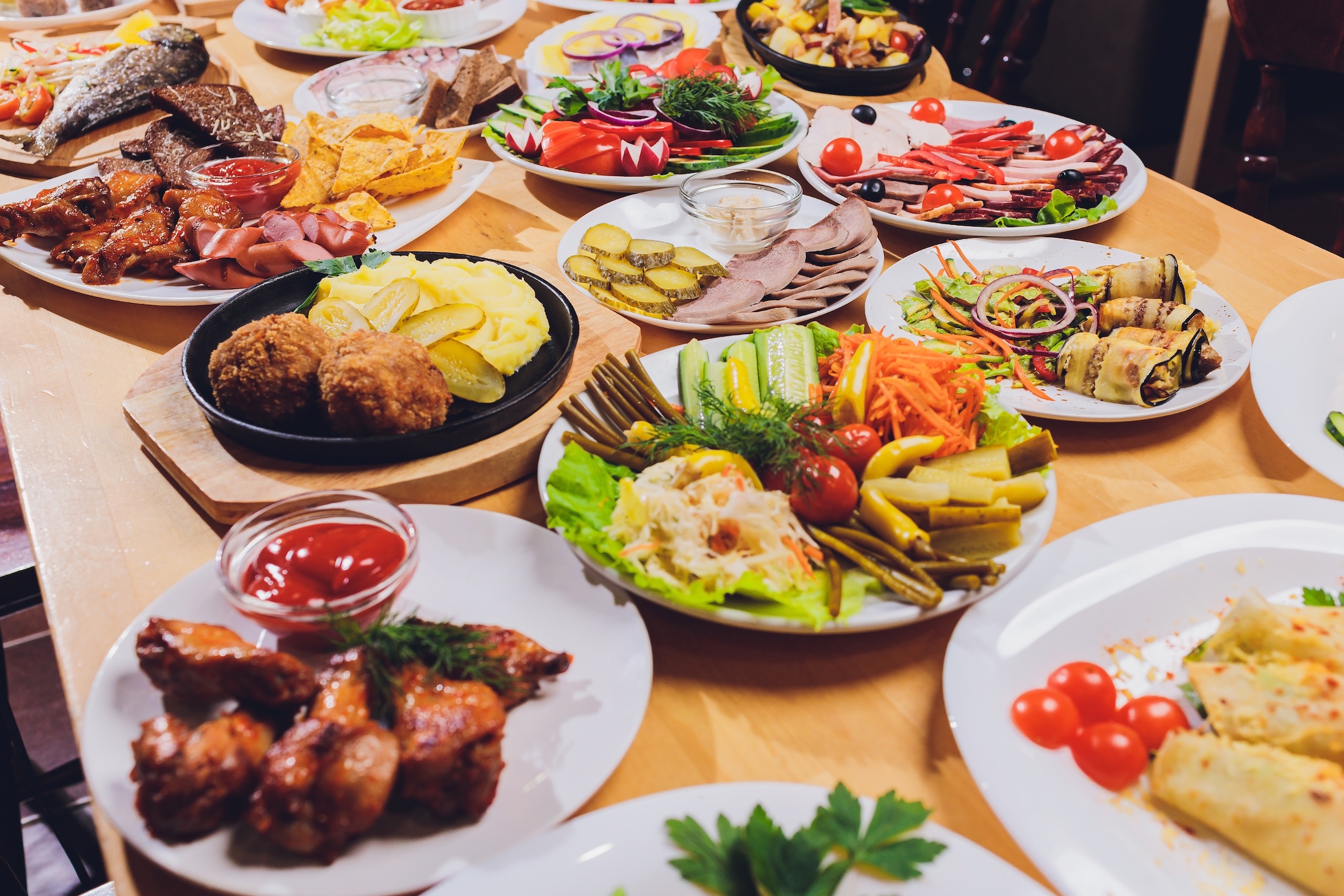 Dining table with a variety of snacks and salads. Salmon, olives, wine, vegetables, grilled fish toast. The concept of a family celebratory dinner. Thanksgiving,